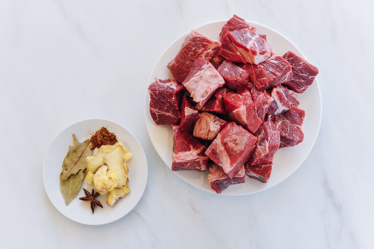 beef stew meat on plate, with aromatics