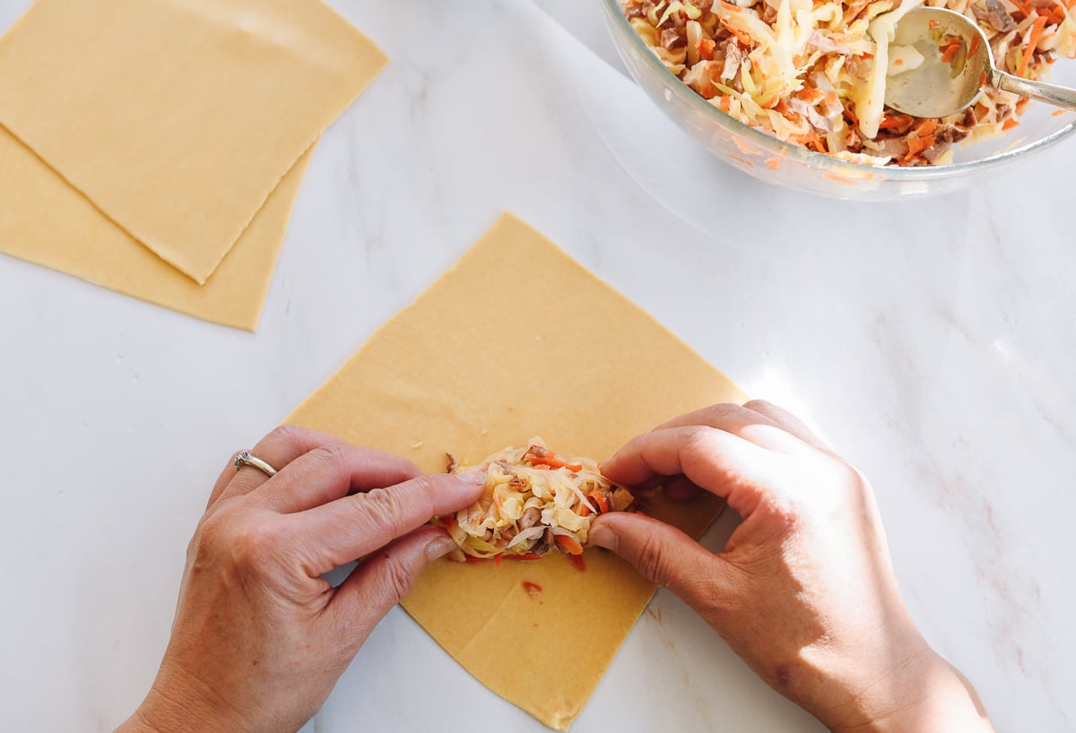 adding filling to egg roll wrapper