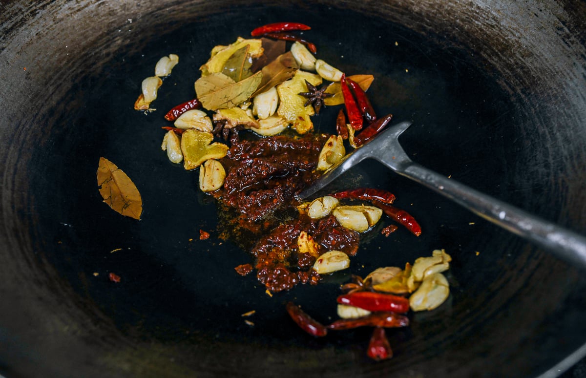 cooking doubanjiang with aromatics in wok