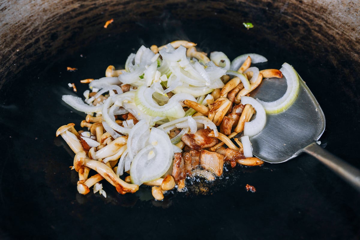 onions added to pork belly and mushrooms